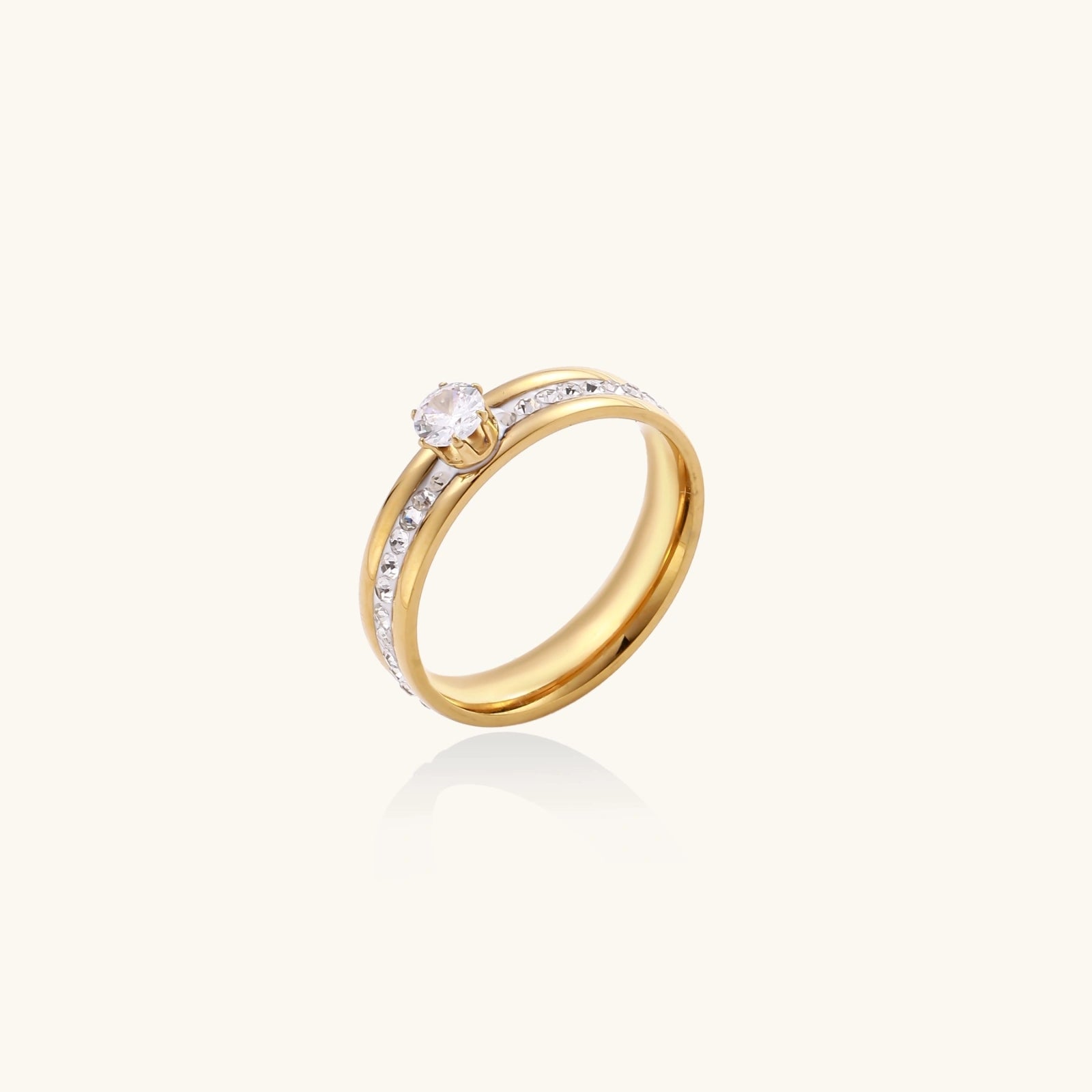 Gold-plated double-band ring with center rhinestone solitaire and channel-set stones on white background